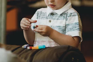 boy holding rainbow lego blocks